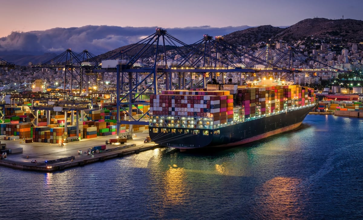 Large container cargo ship being loaded at commercial terminal port