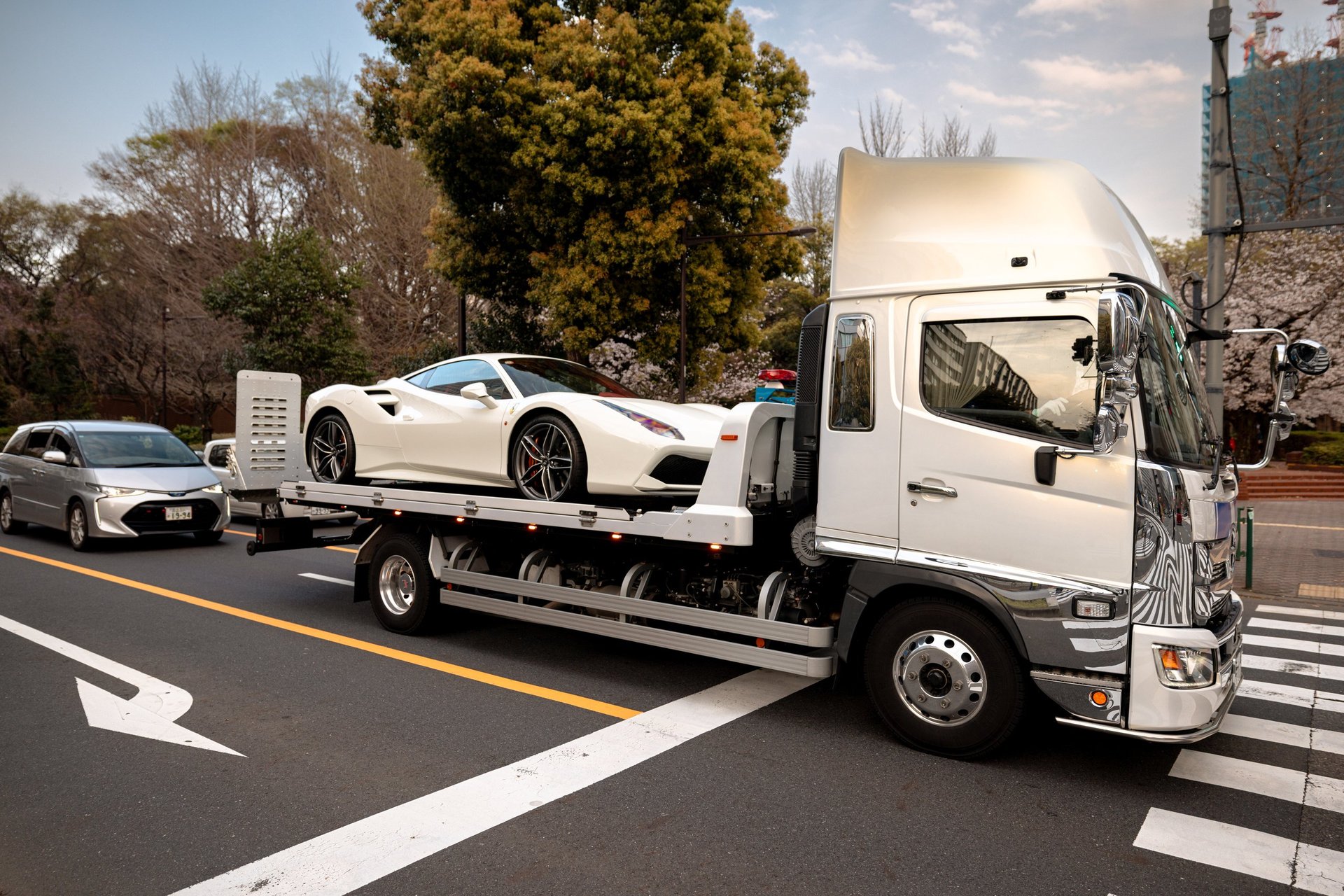 A truck carrying a Ferrari on its rear deck in the Ginza district of Tokyo, Japan