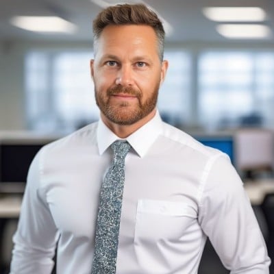 Professional man in white dress shirt and gray tie posing in modern office setting
